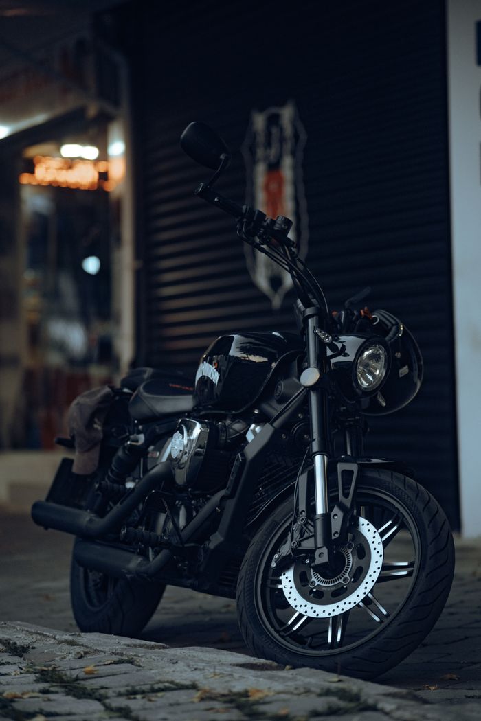 Dark motorcycle parked on a city street in Fethiye, Türkiye, showcasing its sleek design.